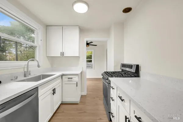 a kitchen with stainless steel appliances granite countertop a sink stove and cabinets