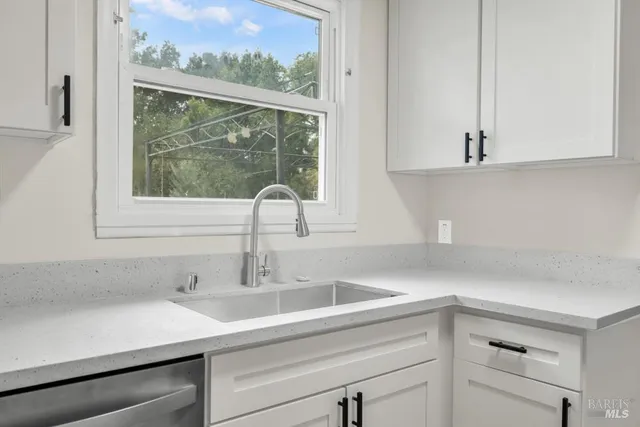 a view of a hallway with wooden floor and a white wall