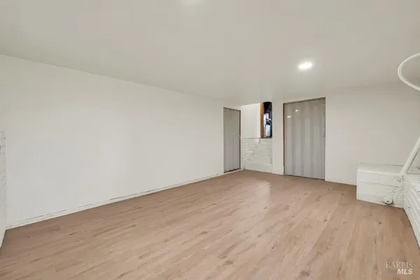 a view of a hallway with wooden floor and staircase