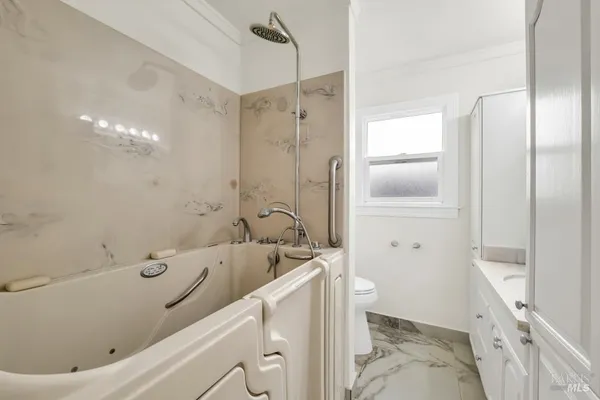 a bathroom with a sink a toilet and shower