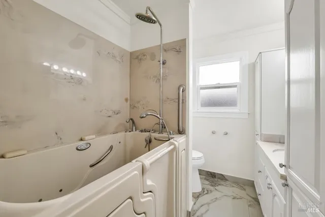 a bathroom with a sink a toilet and shower