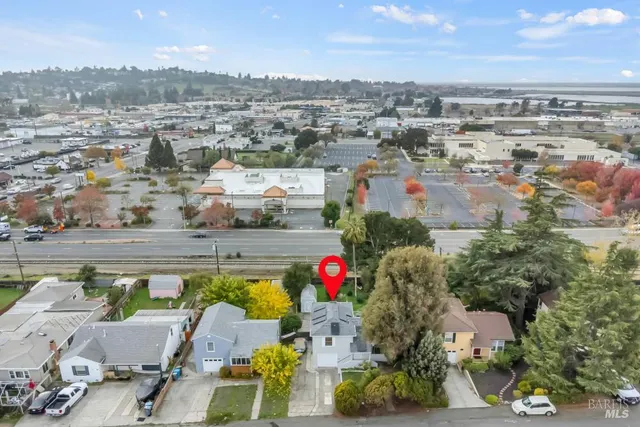 an aerial view of residential houses with outdoor space and trees