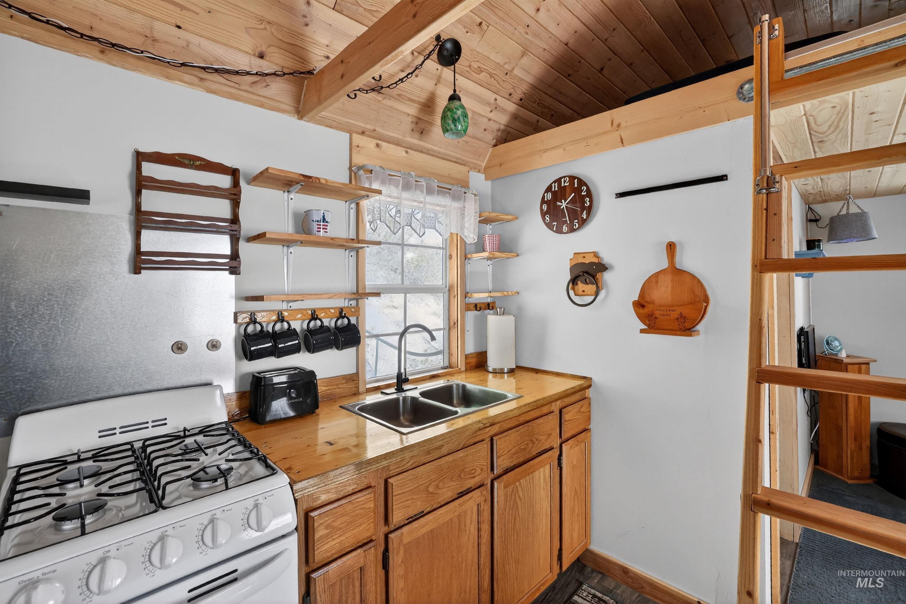 506 Hilltop Road Cascade, ID 83611 - Photo 6 of 36 Kitchen with white gas range oven, open shelves, wood finish cabinetry, wood ceiling, and lofted ceiling with beams