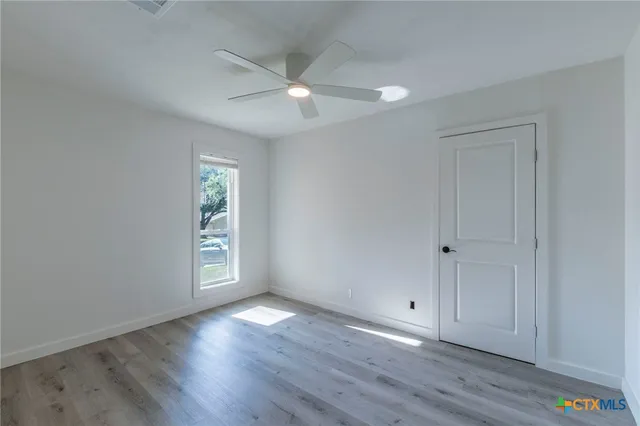 a view of an empty room with wooden floor