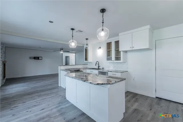a bathroom with a granite countertop sink and a window