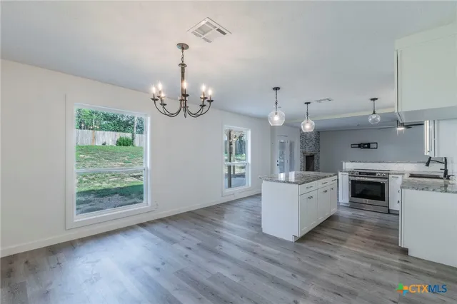 a view of a room with wooden floor chandelier and window