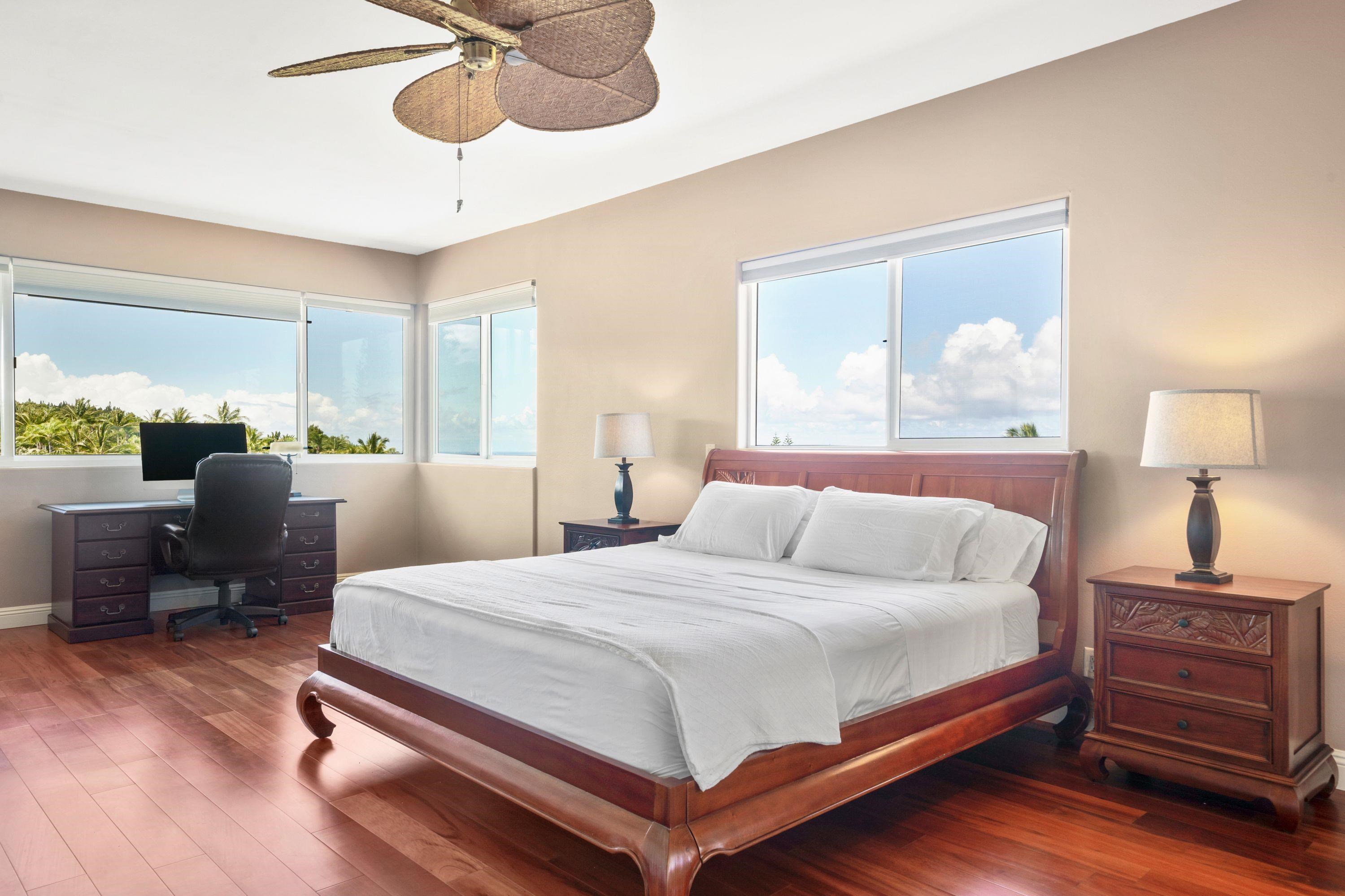 500 North Holokai Place Haiku, HI 96708 - Photo 14 of 30 a bedroom with a bed and a chandelier