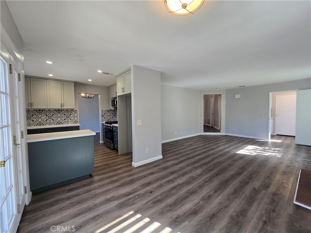 6731 Dove Lane Riverside, CA 92506 - Photo 11 of 28 a view of an empty room and kitchen with wooden floor