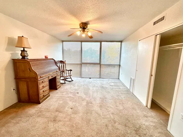 a view of a livingroom with furniture and a ceiling fan