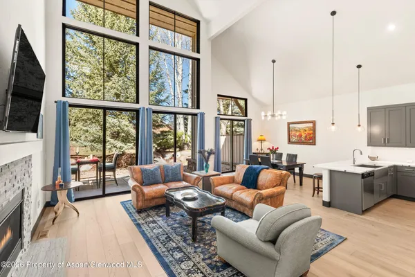 a living room with furniture large window and flat screen tv