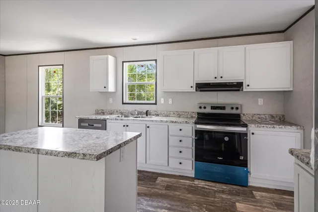 a kitchen with stainless steel appliances granite countertop a stove a sink and a microwave