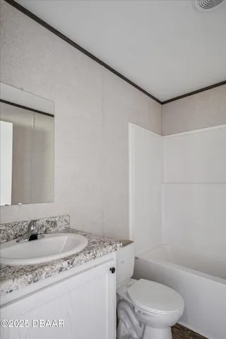 a bathroom with a granite countertop sink a toilet and a mirror