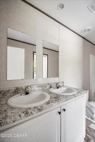 a bathroom with a granite countertop sink and a mirror