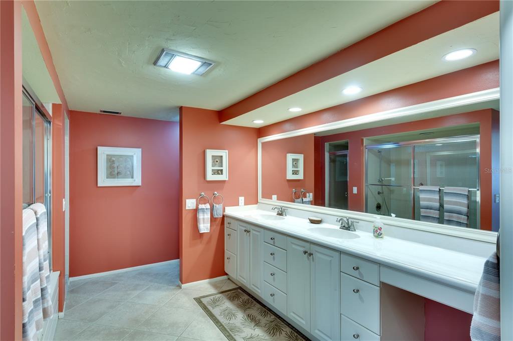 3920 Mariners Way, Unit 311C Cortez, FL 34215 - Photo 13 of 35 a spacious bathroom with a double vanity sink and a mirror