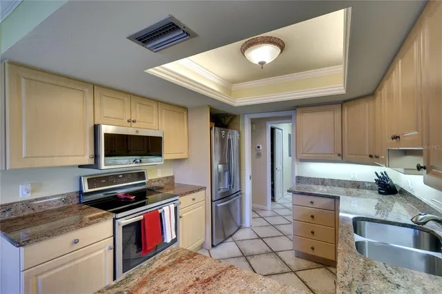 a kitchen with stainless steel appliances granite countertop a stove refrigerator and microwave