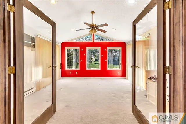 a view of a room with a chandelier fan and windows