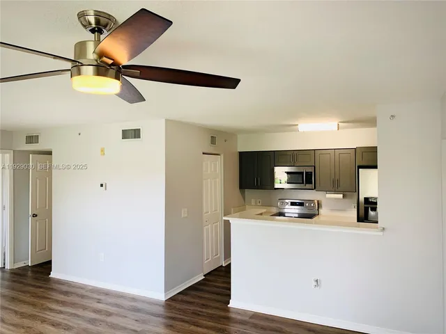 a kitchen view with stainless steel appliances a refrigerator and a microwave