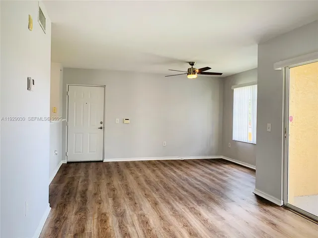 a view of a room with wooden floor and a window