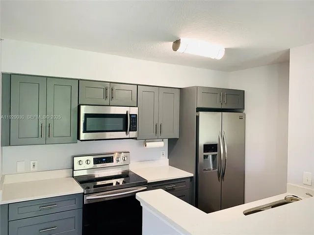 a kitchen with a refrigerator and a stove top oven