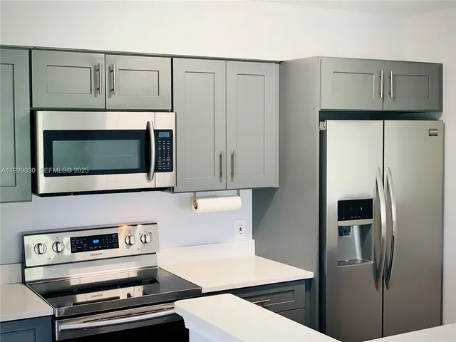 a kitchen with stainless steel appliances a refrigerator a stove and cabinets