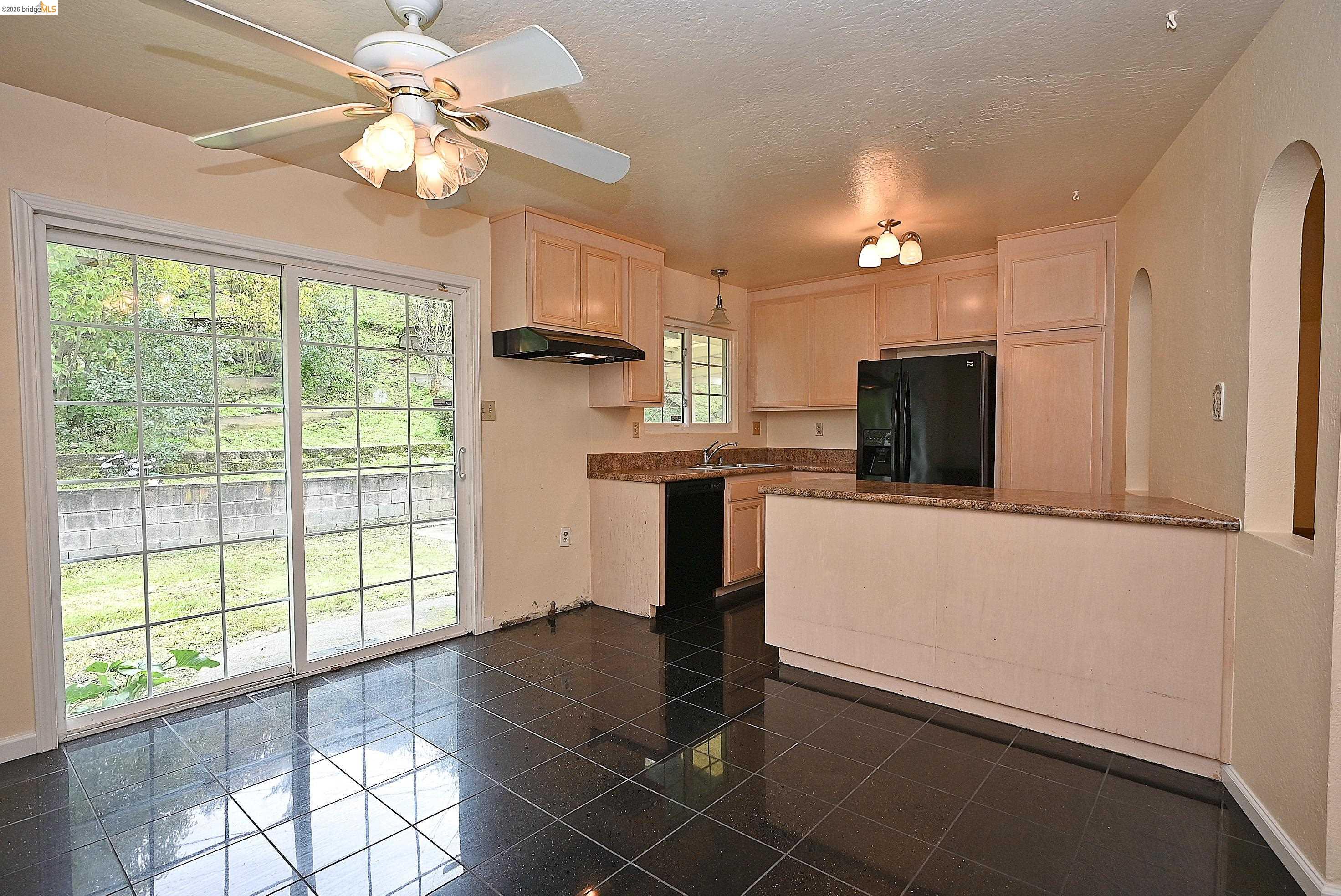 159 Coleridge Drive Vallejo, CA 94591 - Photo 14 of 33 Kitchen featuring light wood finish cabinets, black appliances, dark stone counters, ceiling fan, and a peninsula