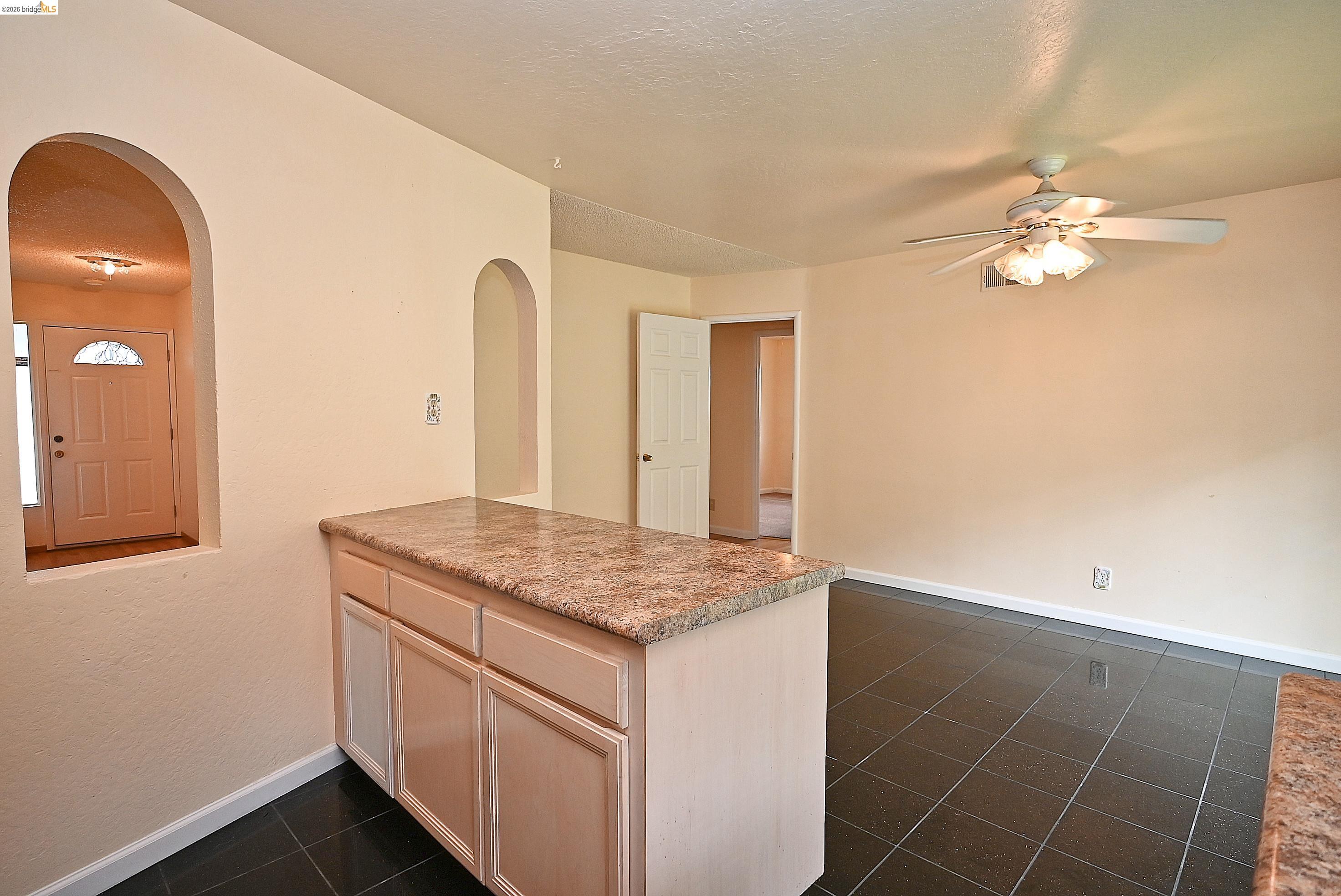 159 Coleridge Drive Vallejo, CA 94591 - Photo 16 of 33 Kitchen with arched walkways, a ceiling fan, light countertops, a peninsula, and light wood finish cabinetry