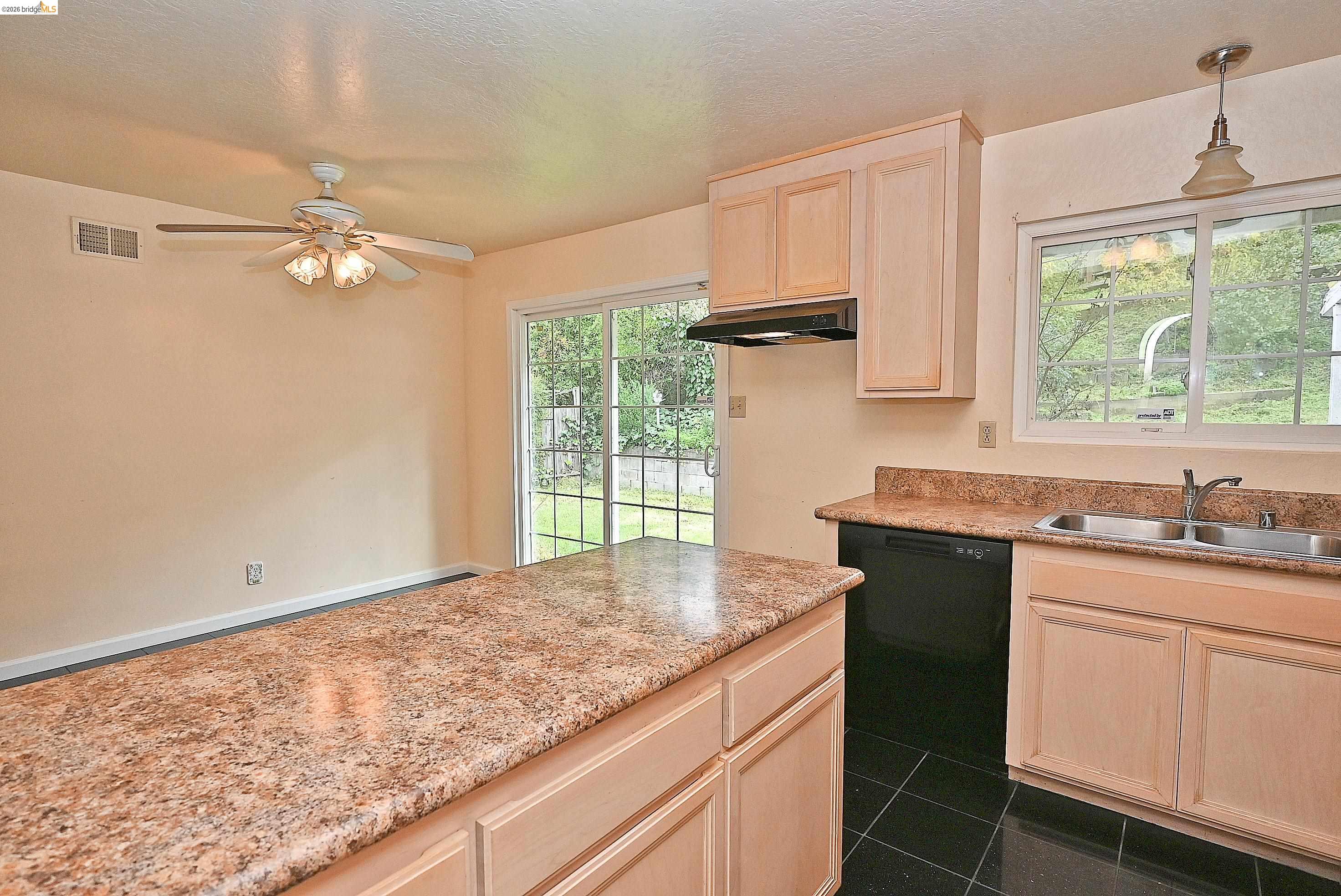 159 Coleridge Drive Vallejo, CA 94591 - Photo 19 of 33 Kitchen with light wood finish cabinetry, black dishwasher, dark tile patterned floors, a ceiling fan, and decorative light fixtures