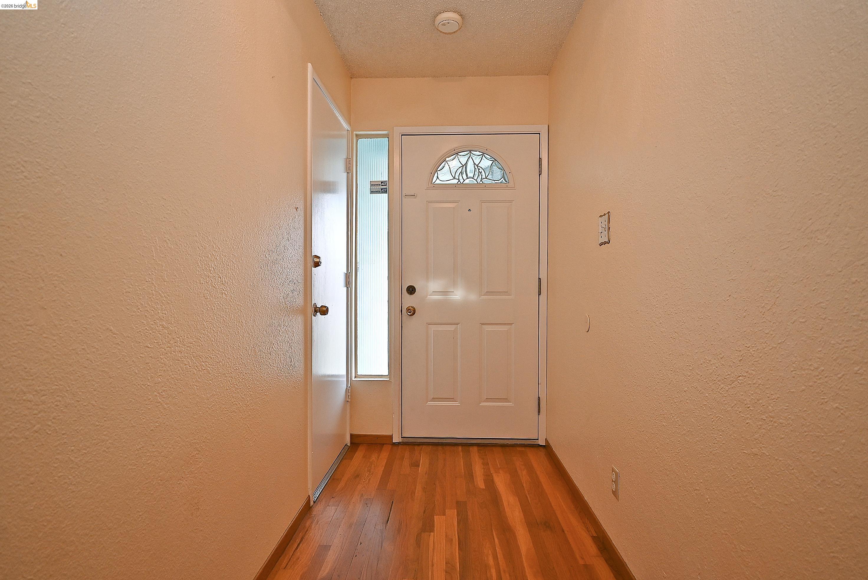 159 Coleridge Drive Vallejo, CA 94591 - Photo 23 of 33 Doorway to outside with a textured wall, wood finished floors, and a textured ceiling