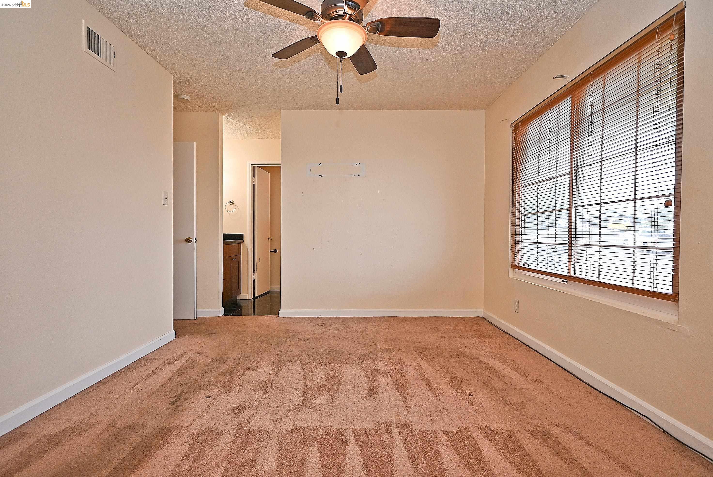 159 Coleridge Drive Vallejo, CA 94591 - Photo 30 of 33 Empty room with a ceiling fan, light colored carpet, and a textured ceiling