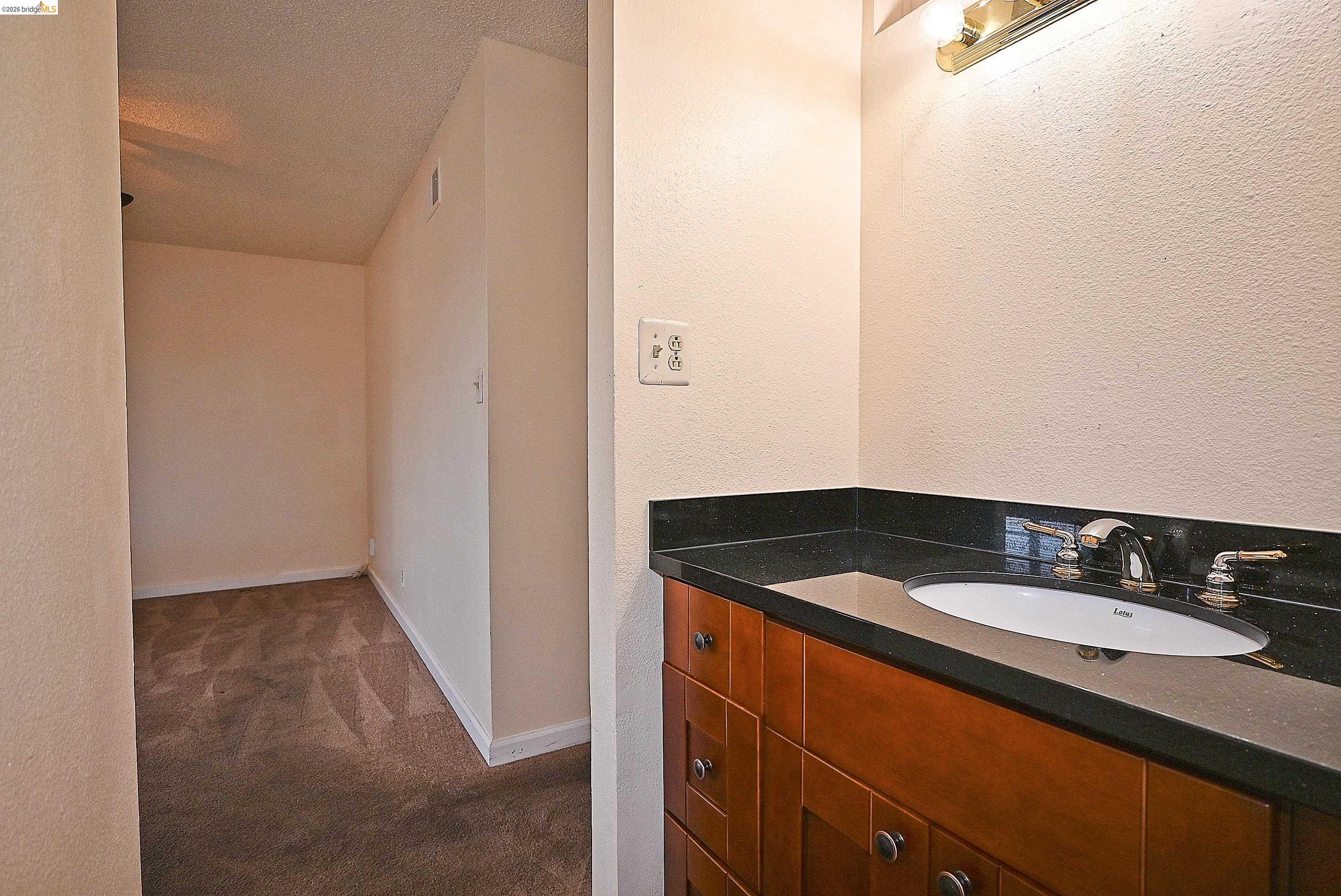 159 Coleridge Drive Vallejo, CA 94591 - Photo 31 of 33 Bathroom featuring a textured wall, vanity, dark carpet, and a textured ceiling