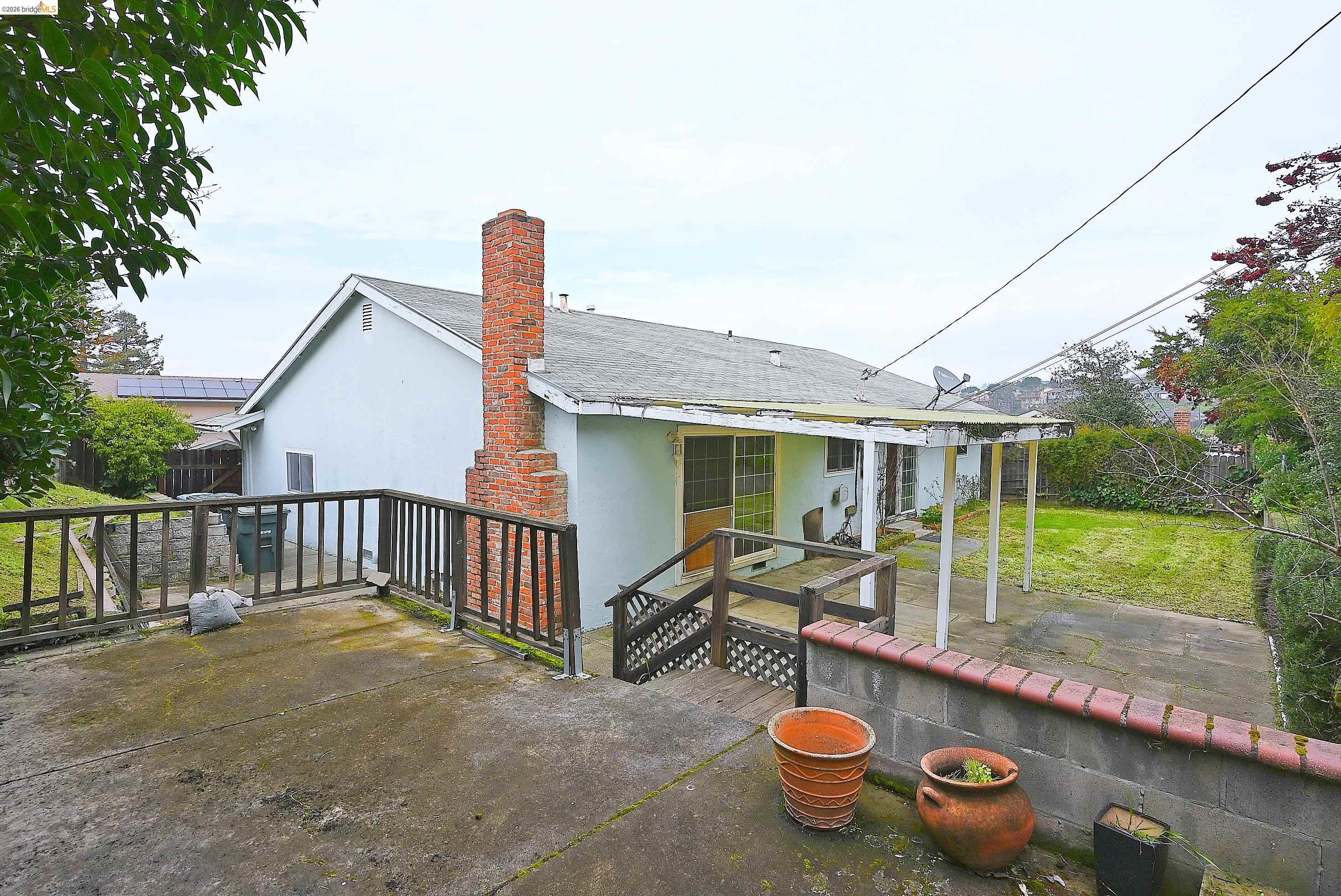 159 Coleridge Drive Vallejo, CA 94591 - Photo 10 of 33 Back of house with stucco siding, a patio area, a chimney, and a shingled roof