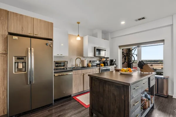 a kitchen with a sink a refrigerator and cabinets