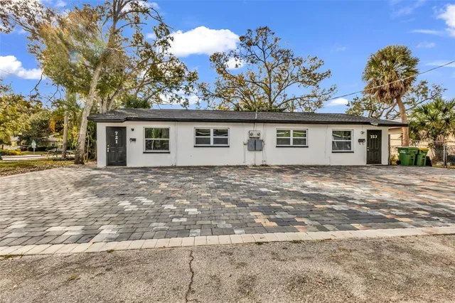 a front view of a house with a yard and trees