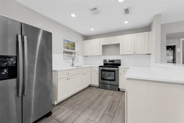a kitchen with a refrigerator stove and sink