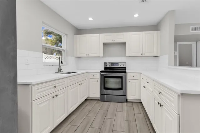 a kitchen with granite countertop white cabinets and appliances