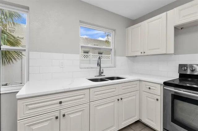 a kitchen with white cabinets and white appliances
