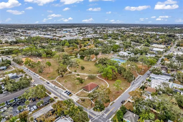an aerial view of residential houses with outdoor space and trees