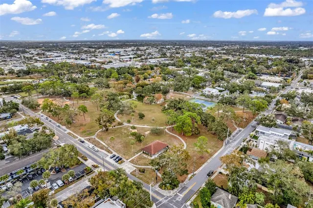 an aerial view of residential houses with outdoor space and trees