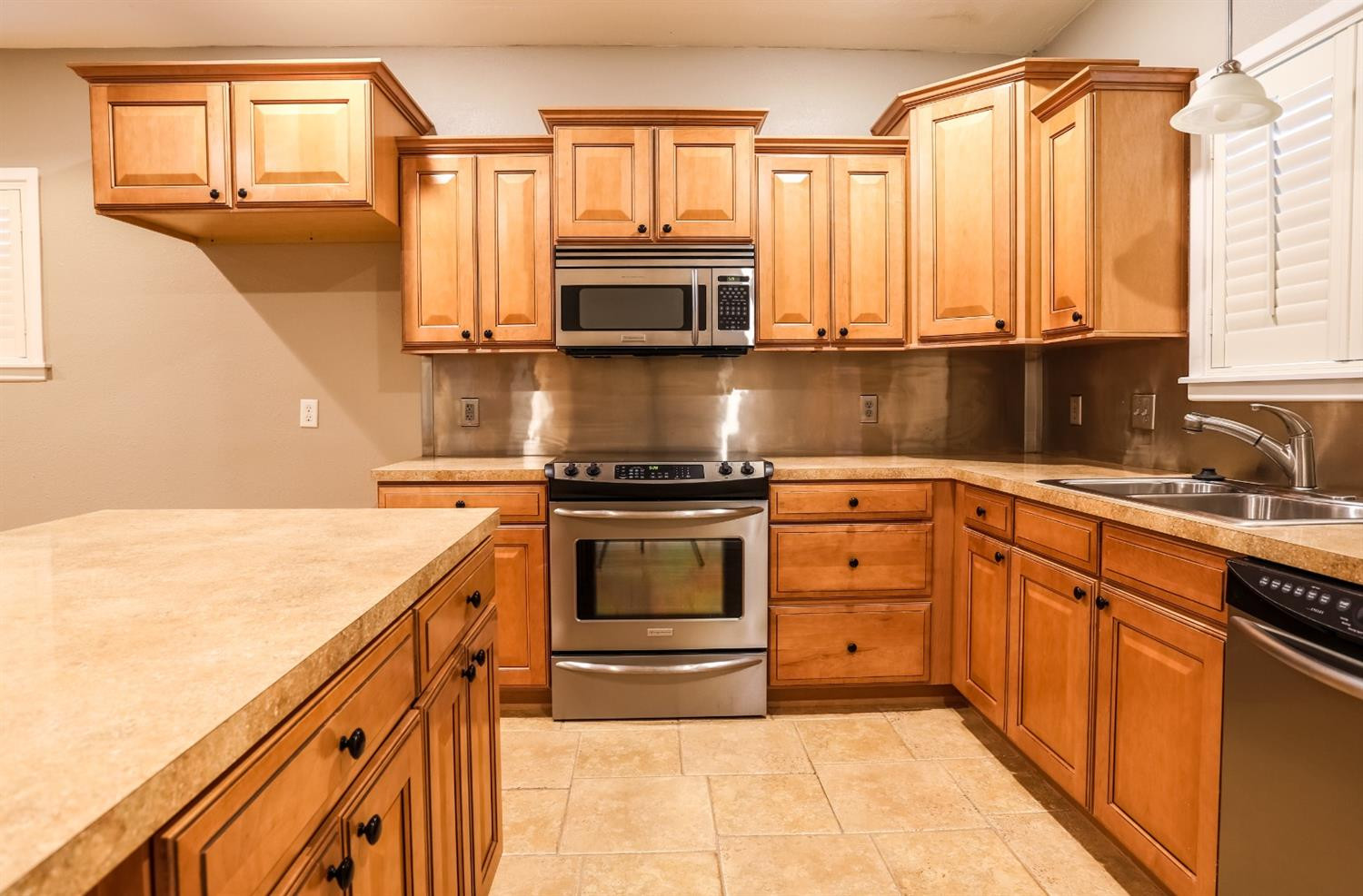 4831 10th Street Lubbock, TX 79416 - Photo 12 of 40 a kitchen with stainless steel appliances granite countertop a stove a sink and a microwave