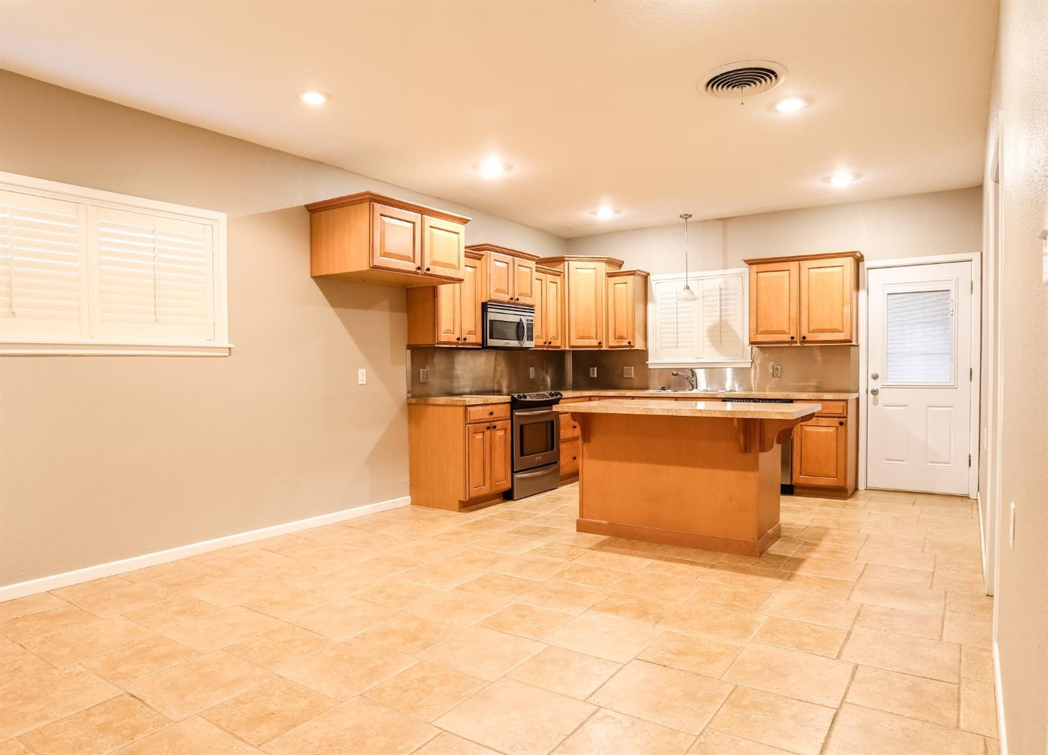 4831 10th Street Lubbock, TX 79416 - Photo 10 of 40 a kitchen with stainless steel appliances a refrigerator sink and cabinets