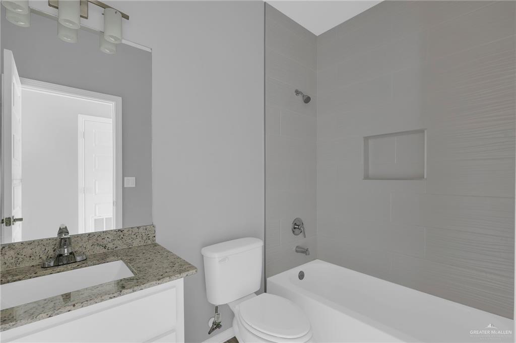 1912 Stauffers Street, Unit 1 Weslaco, TX 78596 - Photo 13 of 14 a bathroom with a granite countertop sink toilet and shower