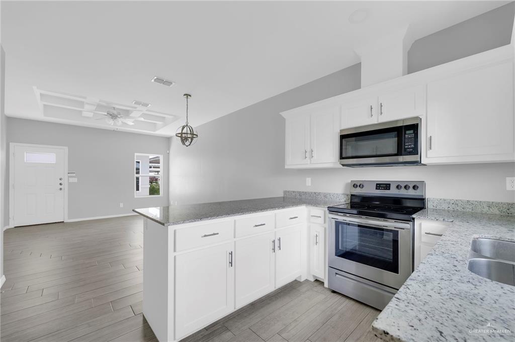 1912 Stauffers Street, Unit 1 Weslaco, TX 78596 - Photo 7 of 14 a kitchen with granite countertop a sink and steel appliances