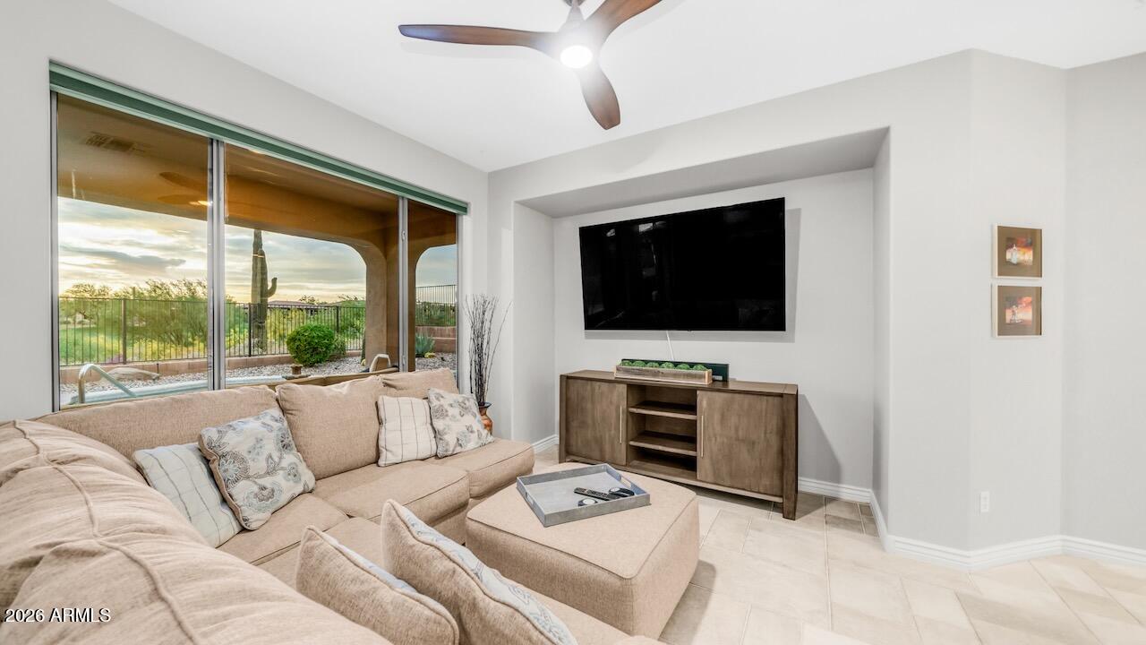 41902 North Crooked Stick Road Anthem, AZ 85086 - Photo 12 of 41 a living room with furniture a flat screen tv and a floor to ceiling window
