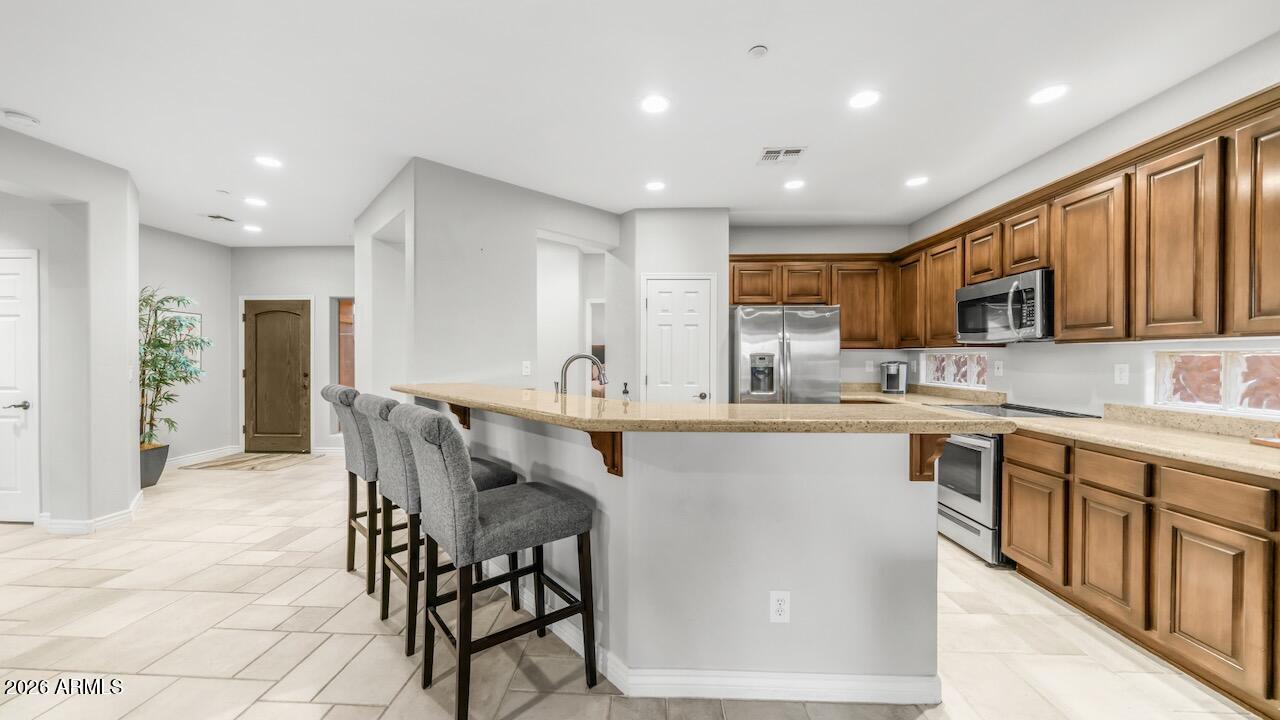 41902 North Crooked Stick Road Anthem, AZ 85086 - Photo 15 of 41 a kitchen with stainless steel appliances granite countertop a table chairs sink refrigerator and cabinets