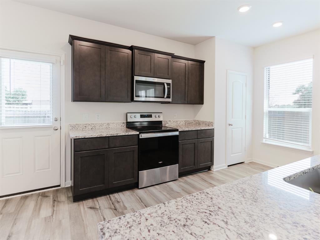 608 Aqueduct Drive Seagoville, TX 75159 - Photo 4 of 20 a kitchen with granite countertop a refrigerator and a stove top oven