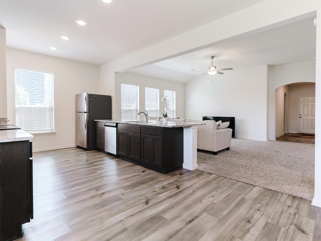 608 Aqueduct Drive Seagoville, TX 75159 - Photo 6 of 20 a kitchen with stainless steel appliances kitchen island granite countertop wooden floors and granite counter tops