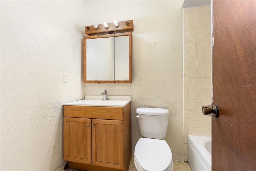 3116 West University Avenue Gainesville, FL 32607 - Photo 18 of 31 a bathroom with a toilet a sink and mirror