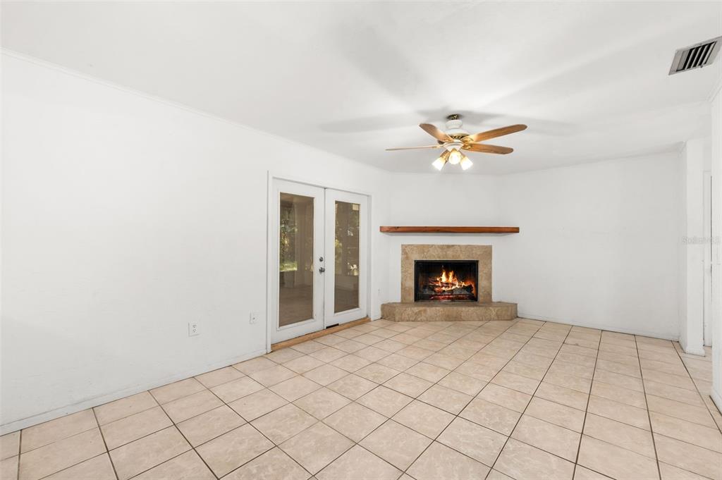 3116 West University Avenue Gainesville, FL 32607 - Photo 7 of 31 a view of an empty room with a fireplace and a ceiling fan