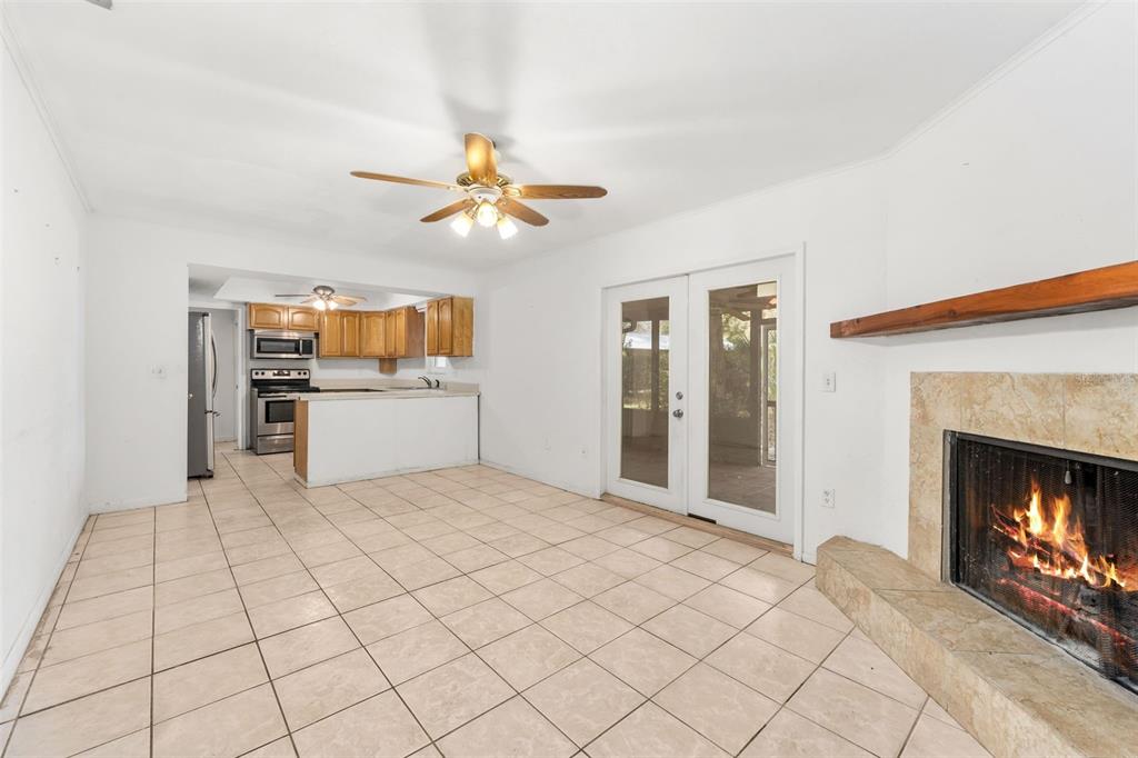 3116 West University Avenue Gainesville, FL 32607 - Photo 8 of 31 a view of a kitchen with a fireplace a ceiling fan and wooden floor