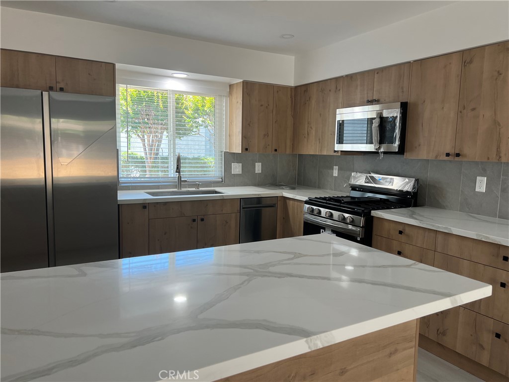 7561 Donna Avenue Reseda, CA 91335 - Photo 6 of 30 a kitchen with stainless steel appliances a sink a stove a microwave a counter top space